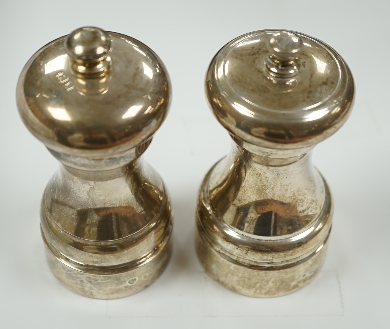 Two modern silver mounted pepper grinders, tallest 10.2cm.